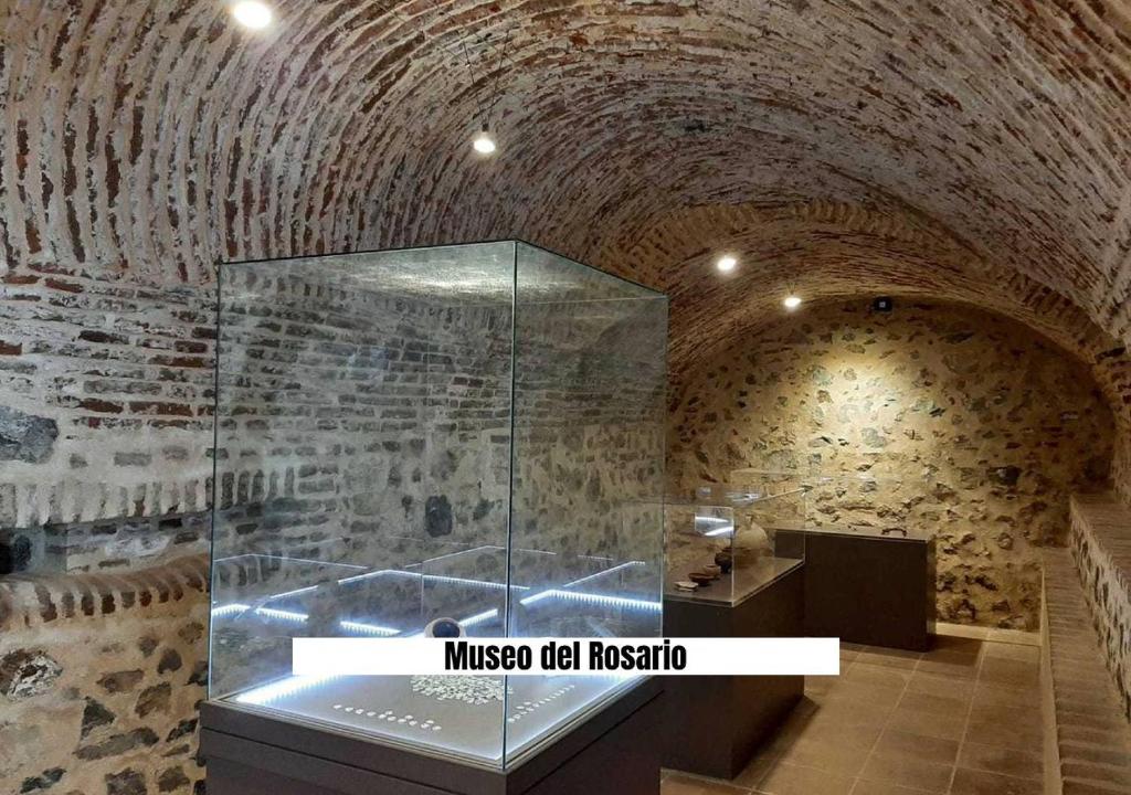 a museum with a glass exhibit in a brick room at Ruralux Aroche in Aroche