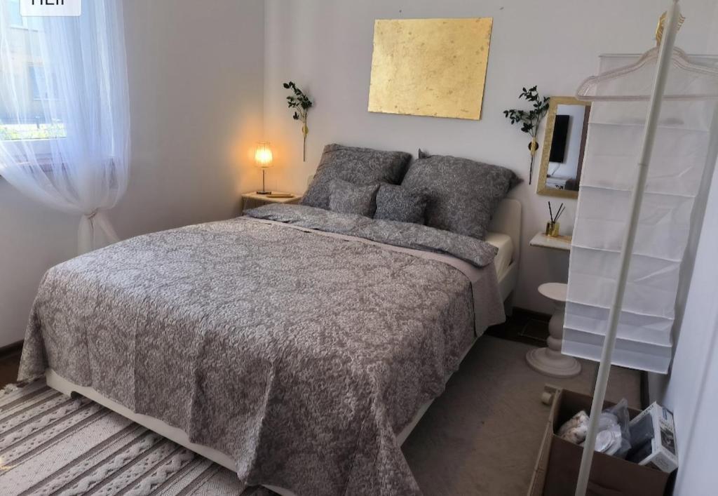 ein Schlafzimmer mit einem Bett mit einer grauen Bettdecke in der Unterkunft Apartment with terrace and barbecue area in Mosty