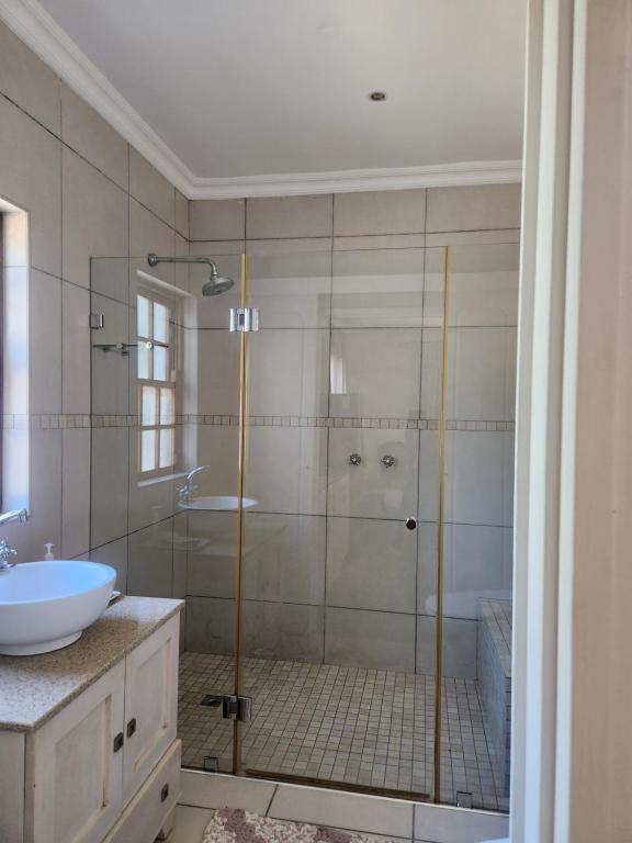 a bathroom with a shower with a tub and a sink at Somerset West Stay 2 in Somerset West
