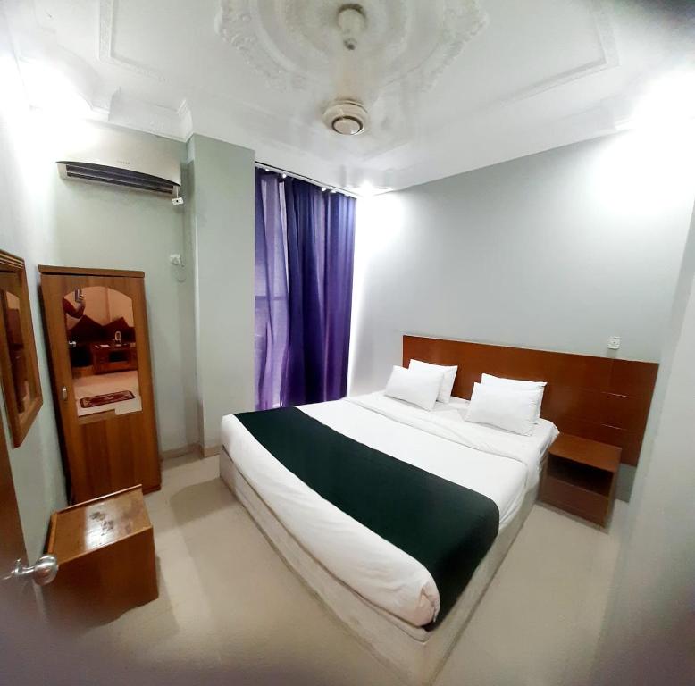 a bedroom with a large white bed in a room at Hotel Bay Marina in Cox's Bazar
