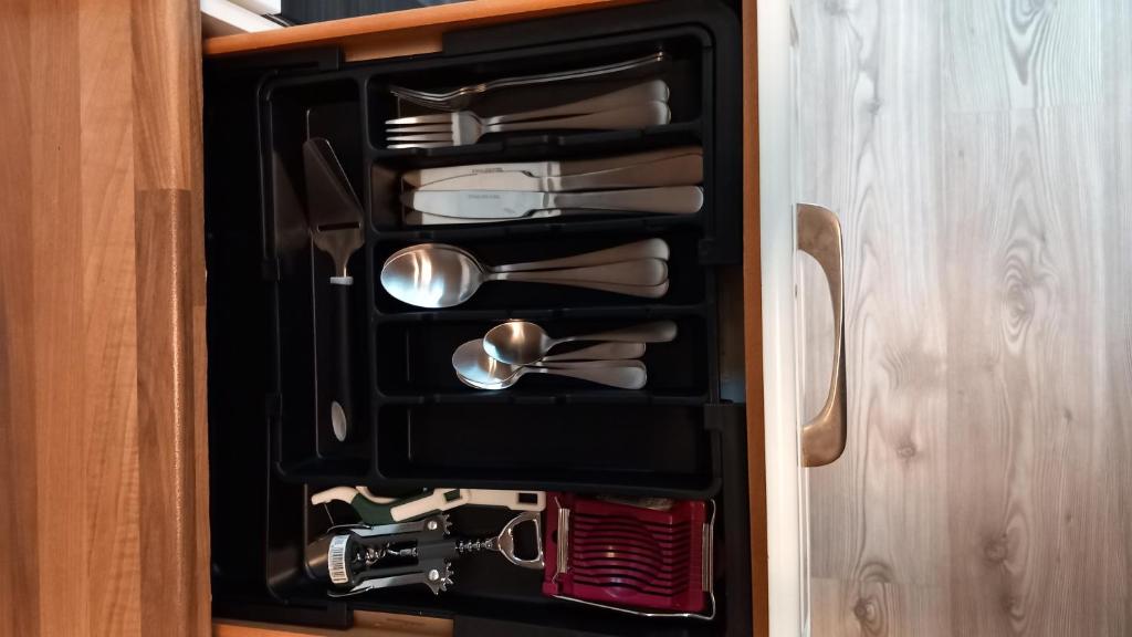 a drawer filled with silver utensils in a cabinet at Holiday Nest 2 in Sønderborg