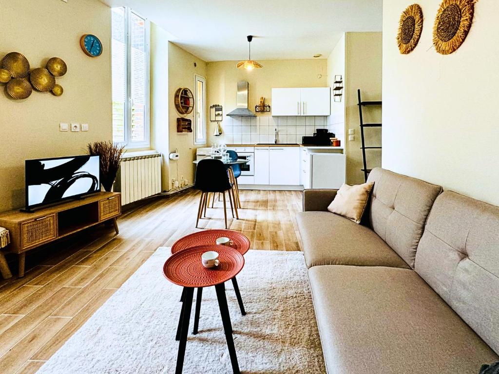 a living room with a couch and a table at Le Saint Savinien - By 69ALSACELO - Patio Privé - Idéal Couple & Pros - Canapé convertible - Centre Ville - WiFi Fibre - Check-in Autonome - Parking Facile & Gratuit in Sens