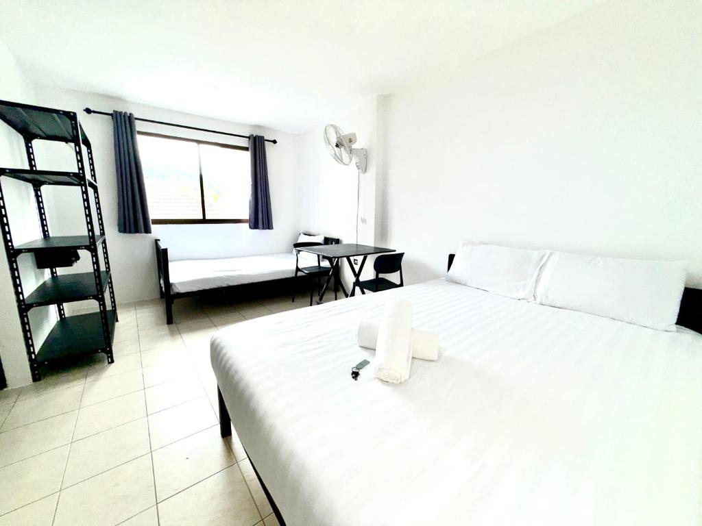 een slaapkamer met een groot wit bed en een tafel bij Patong Canal Villa R202 in Patong Beach