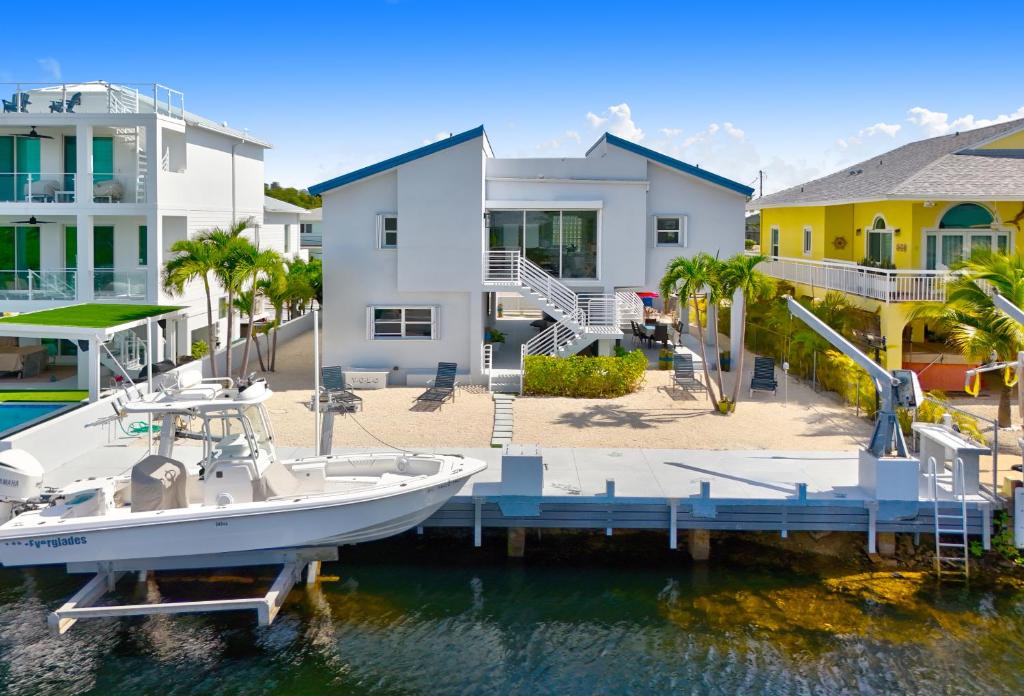 キーラーゴにあるKeys Harbor - Waterfront, Private Boat Dock, Outdoor Oasisの家の前の桟橋に停泊する船