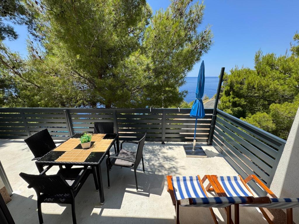 a patio with a table and chairs and an umbrella at Apartments Rotim, Mljet, Sutmiholjska in Babino Polje