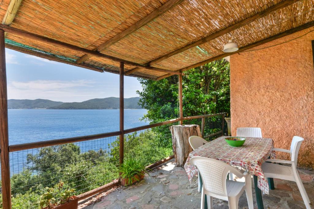 a table and chairs on a patio with a view of the water at Cotetonda - Appartamento Taccola in Marciana Marina