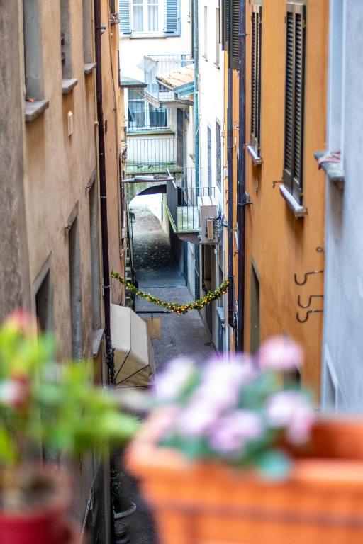 an alley with buildings and flowers in a city at Comodità a due passi dal lago in Verbania