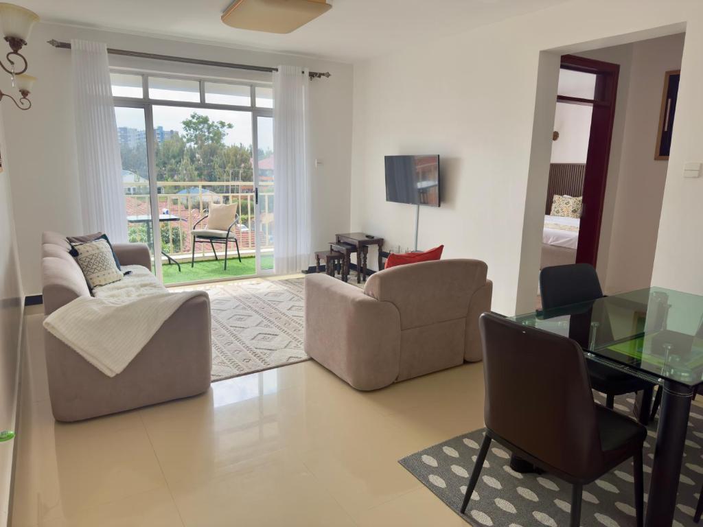 a living room with two chairs and a glass table at Best homes apartments near JKIA in Nairobi