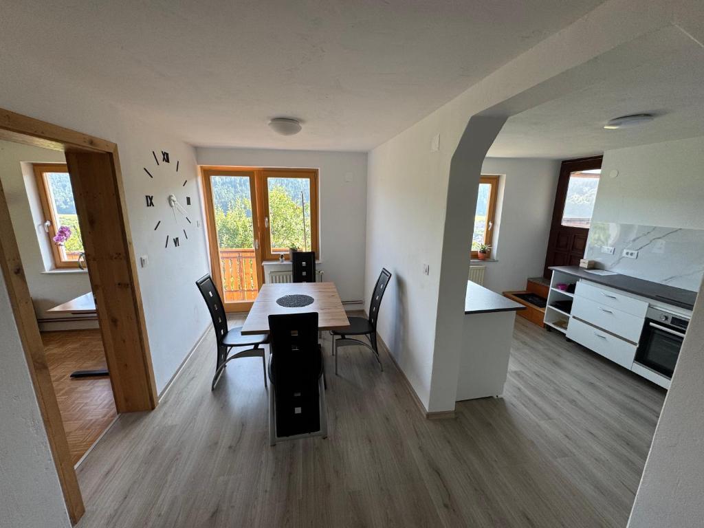 a kitchen and dining room with a table and chairs at Apartma Petra in Selca