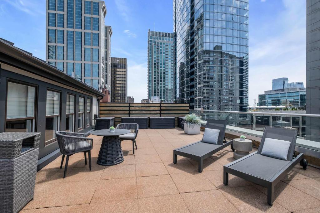a patio with chairs and tables on top of a building at Skyline Suite with Penthouse & Rooftop Deck 6BR by Maddox Hotel in Nashville