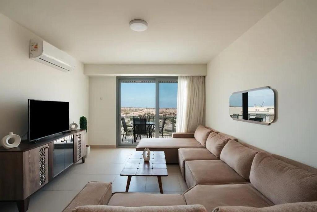 a living room with a couch and a television at Marassi Faya 3BR Retreat in El Alamein