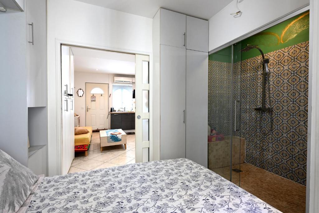 une chambre avec un lit et une douche à l'italienne dans l'établissement Un jardin en Ville, à Nice
