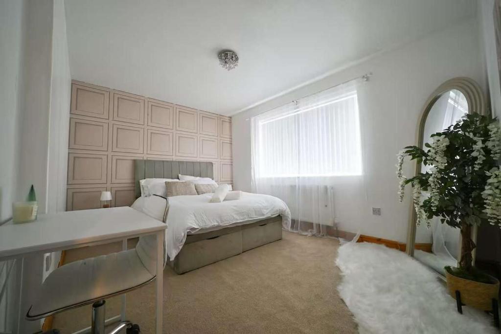 a white bedroom with a bed and a window at Wythenshawe Greenbrow Retreat in Manchester