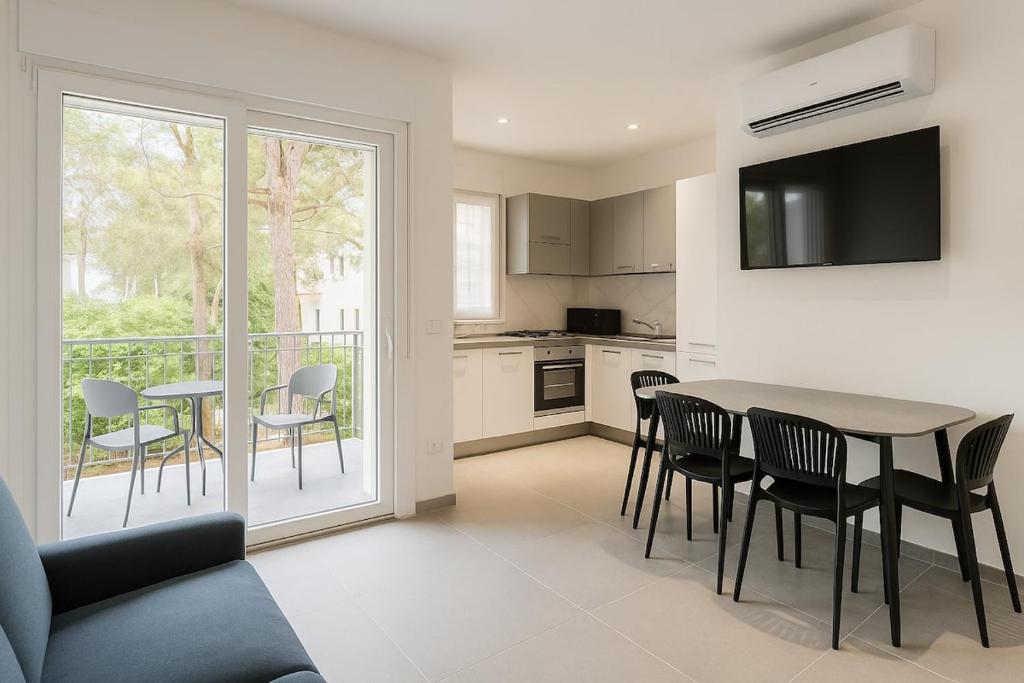 a kitchen and dining room with a table and chairs at Modern apartment with parking in Lignano Sabbiadoro