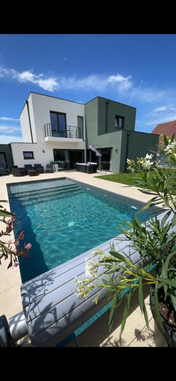 a house with a swimming pool in front of a house at Maison spacieuse au calme proche Colmar avec piscine in Niederentzen
