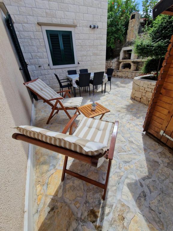 a group of chairs and tables on a patio at Apartment CHARLY in Supetar