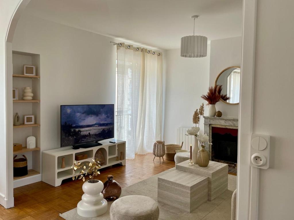 a white living room with a television and a fireplace at Le Refuge de l'hyper centre de Compiègne in Compiègne