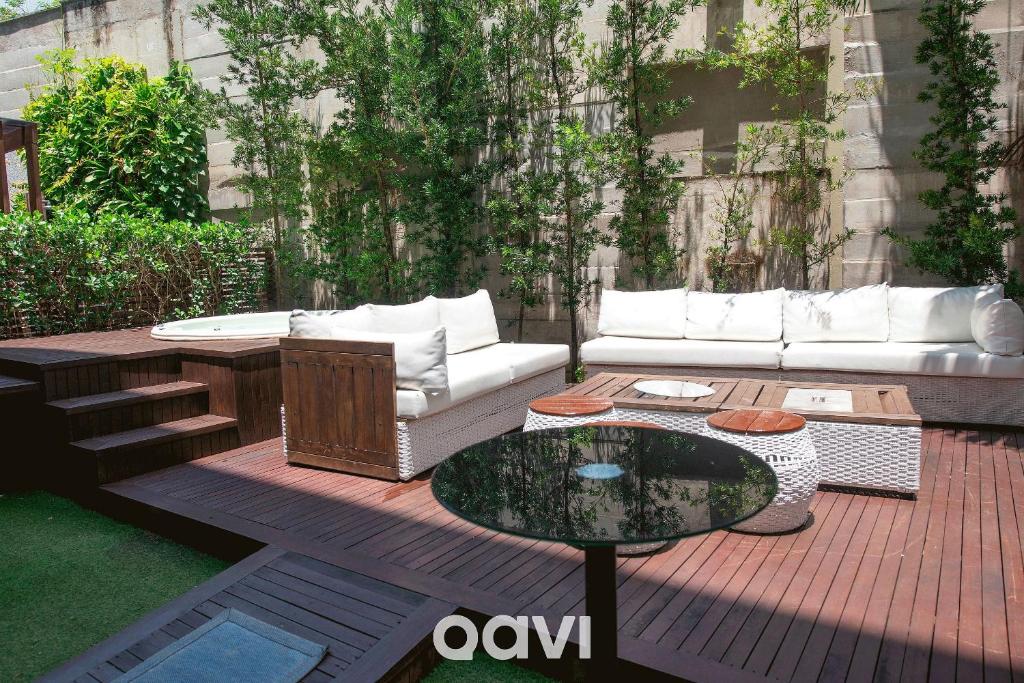 a patio with a couch and a glass table at Apto. com Jacuzzi em Cotovelo In Mare by QAVI in Granja Beira Mar