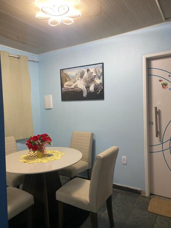 a room with a table and chairs and a picture of a dog at Passagem do Rosário 92,icoaraci in Belém
