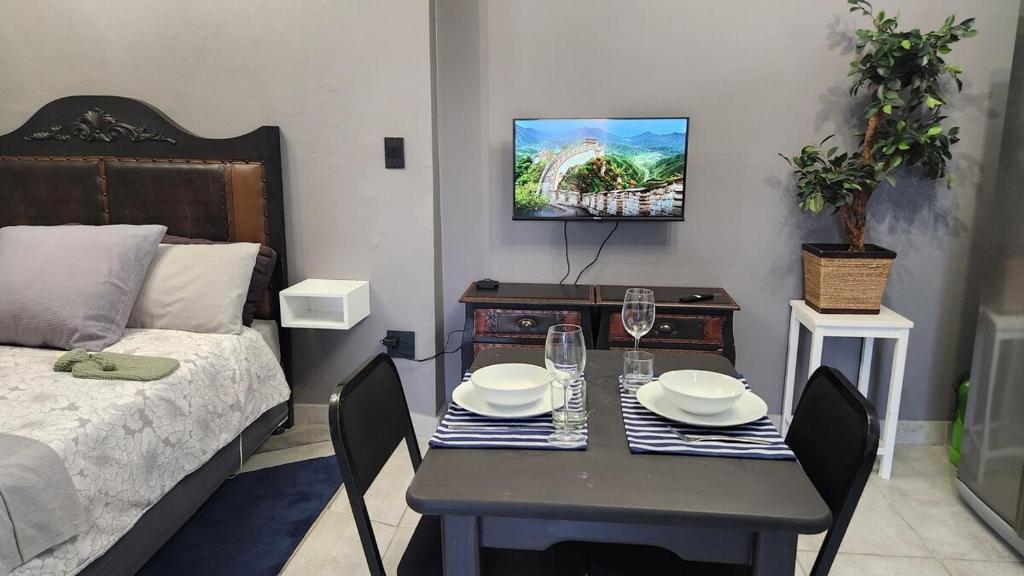 a small room with a table and a bed at GreenMarket Studio in Knysna