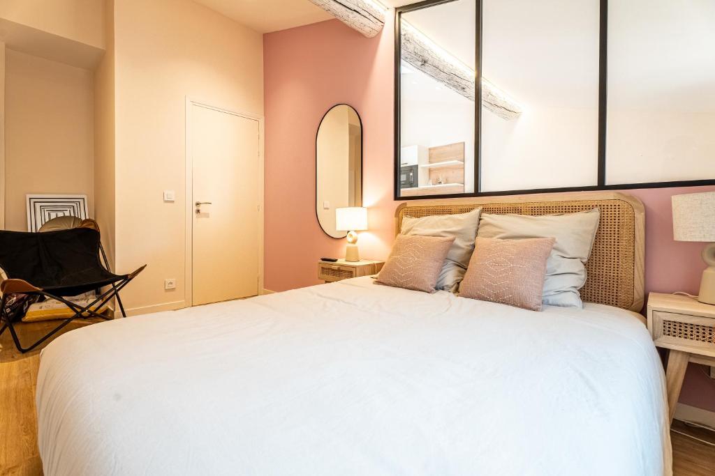 une chambre avec un grand lit et un miroir dans l'établissement Le Toit d'Azur, à Nice