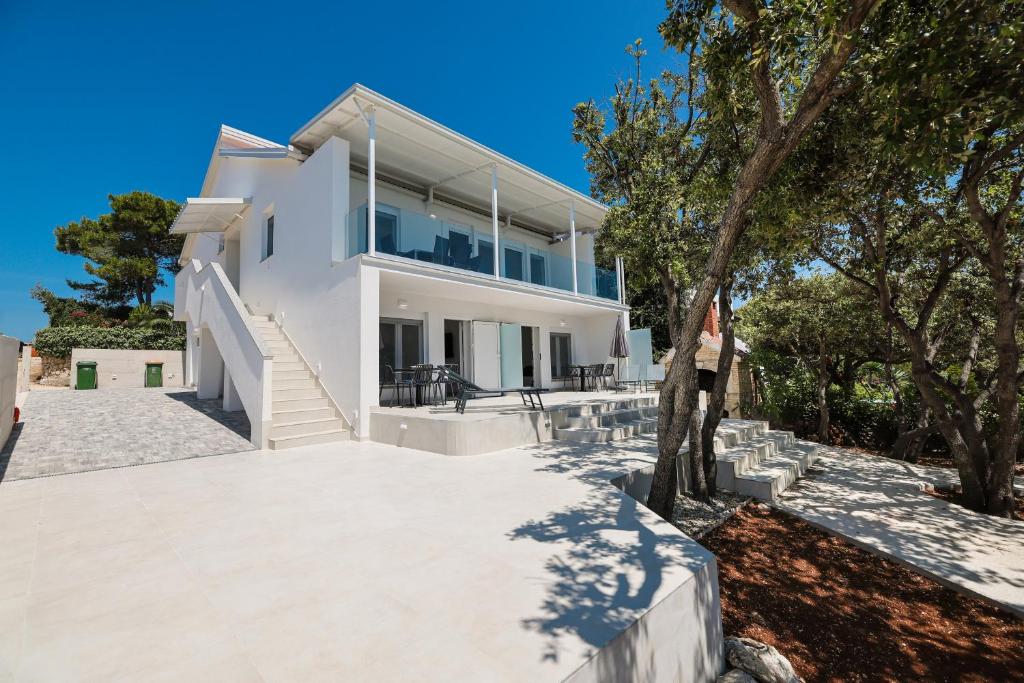 a large white house with trees in front of it at Villa Mir Punta Radman in Petrcane