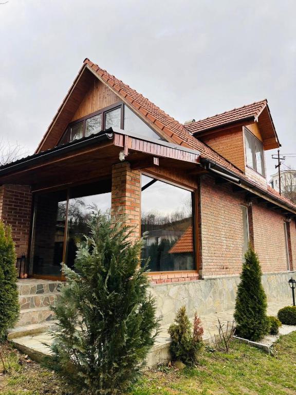 a house with a large window on the front of it at Cabana Ana in Feleacu