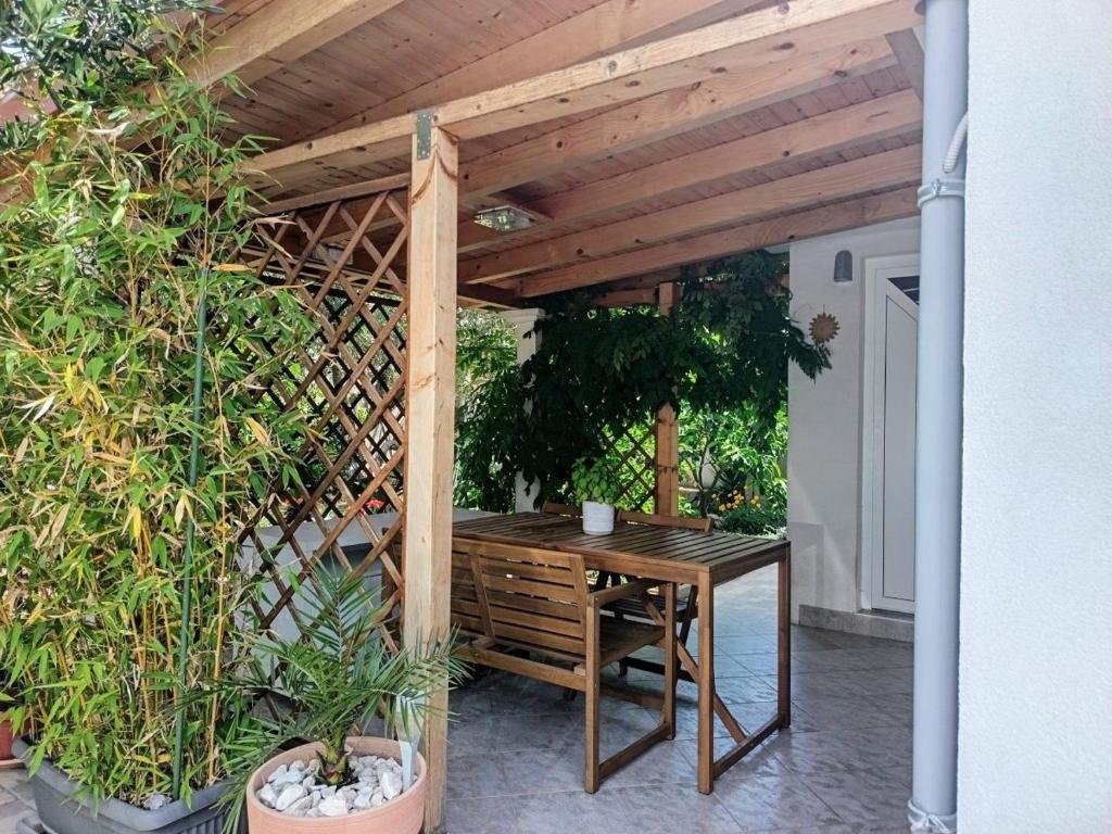 pérgola de madera con mesa de madera en el patio en Bungalow 3743-4 Pers in Razanj, en Ražanj