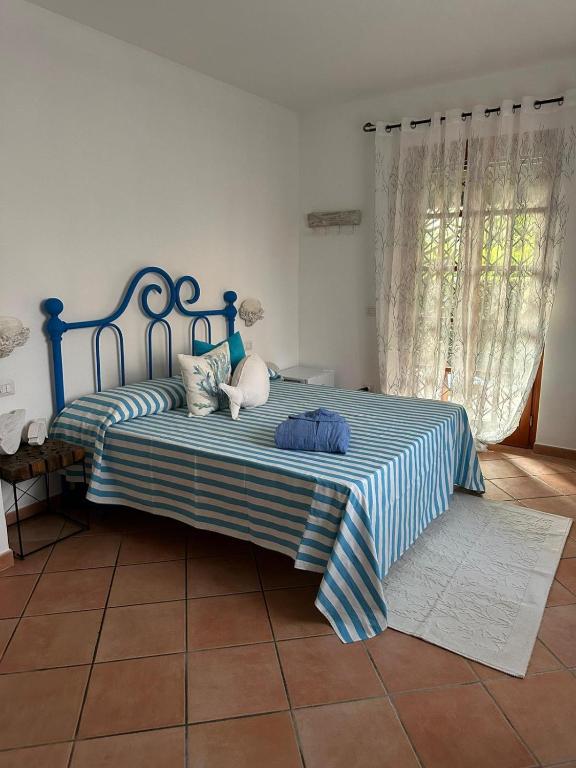 a bedroom with a bed with a blue and white blanket at La Casa di SASI in Sabaudia
