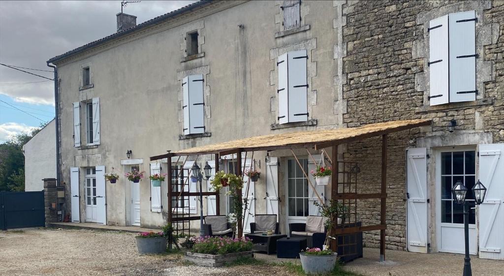 an old brick building with chairs in front of it at Large French Farmhouse in Néré