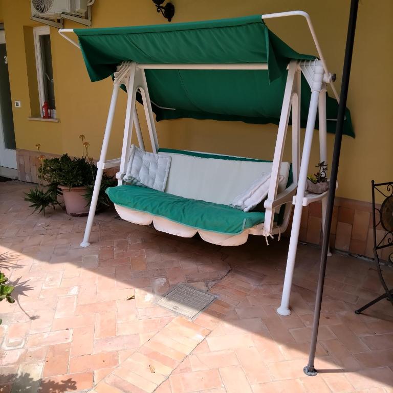 a porch swing with a green canopy at B&B VILLA RITA in Silvi Marina