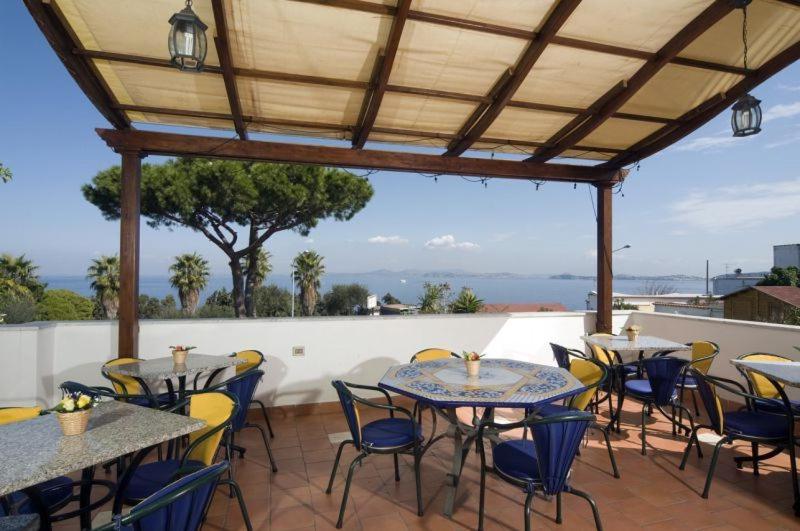 a patio area with tables, chairs and umbrellas at Hotel Gemma in Ischia
