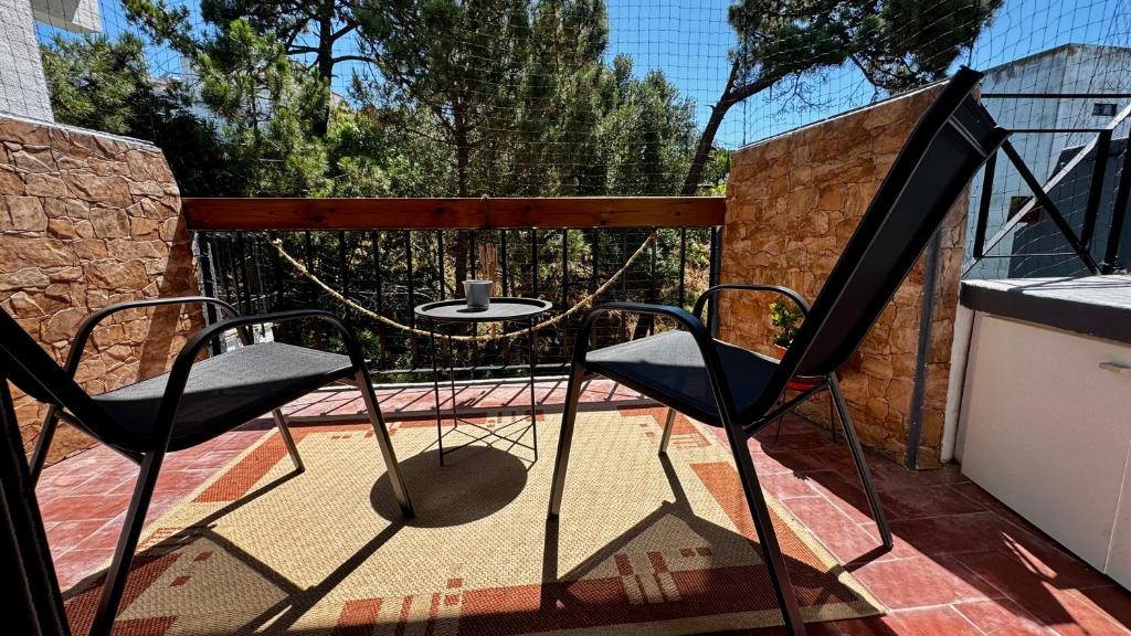 a patio with two chairs and a table on a balcony at THE Estoril Studio in Estoril
