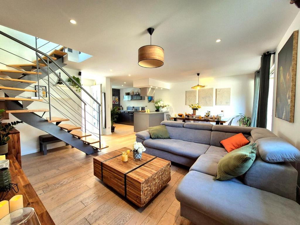 un salon avec un canapé et une table dans l'établissement La Maison des Iris - clim - patio - parking, à Nîmes