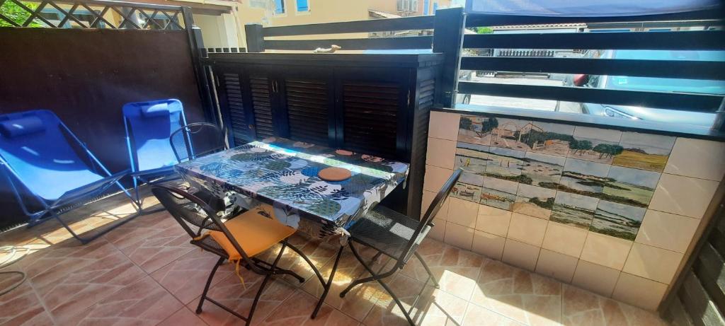 une table et des chaises assises dans une pièce avec un mur dans l'établissement La maison de la mer, classée 3 étoiles, à Frontignan