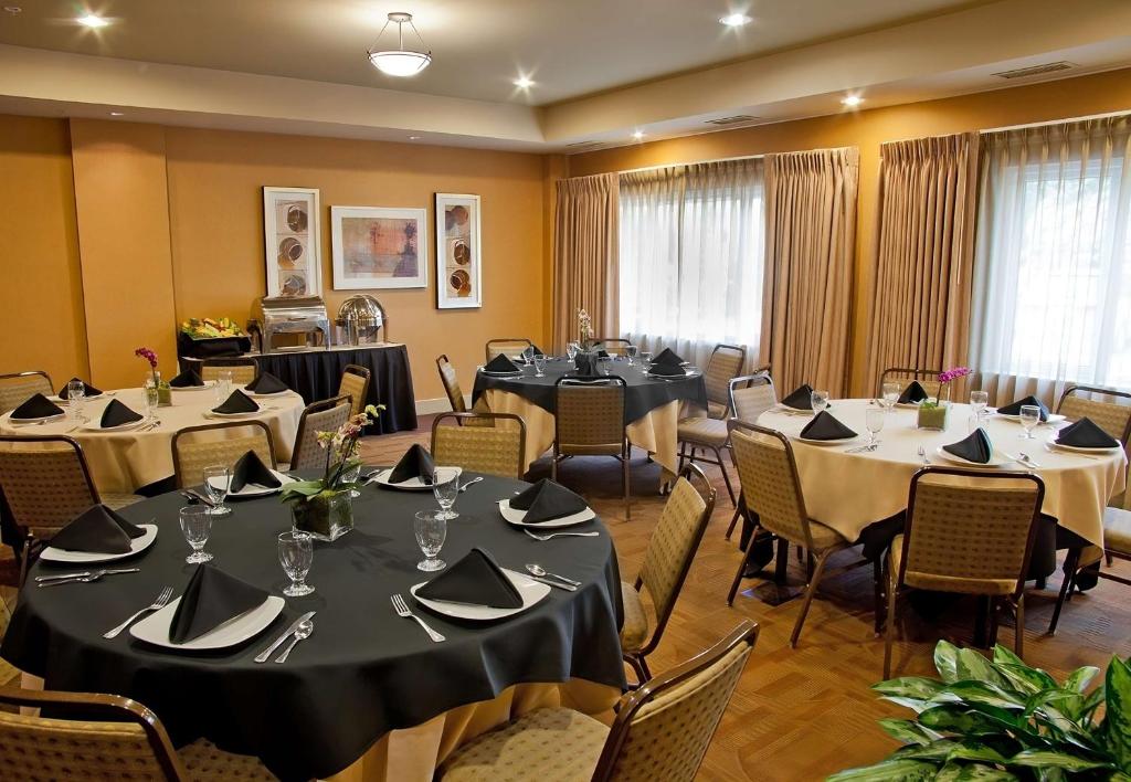 einen Konferenzraum mit Tischen, Stühlen und einem Tisch in der Unterkunft Eastgate Hotel - BW Signature Collection in Bellevue