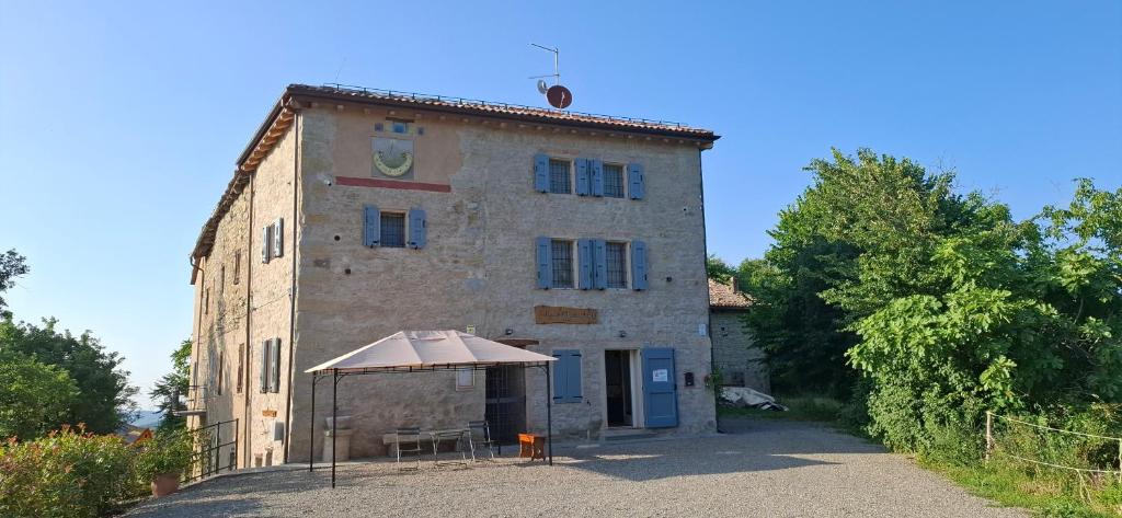 een oud gebouw met een paraplu ervoor bij Il Castellaro ai Sassi in Guiglia