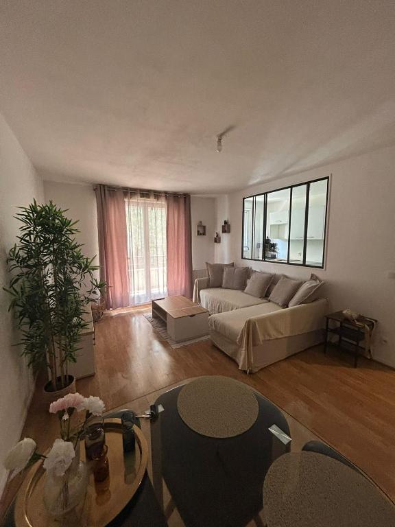 un salon avec un canapé et une table dans l'établissement Charmant 2P Cosy Bord de Seine avec terrasse, à Mantes-la-Jolie