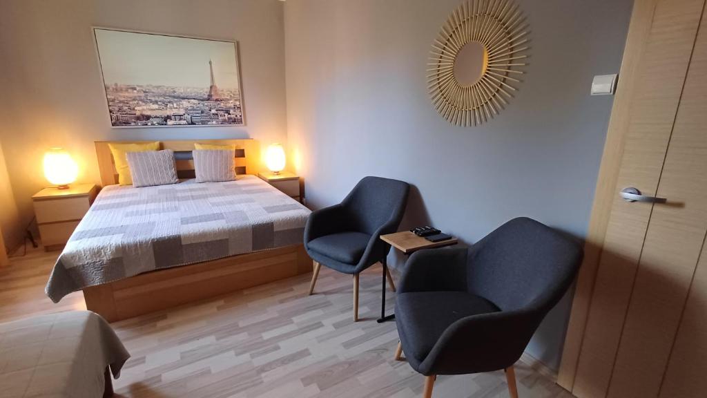 sypialnia z łóżkiem, 2 krzesłami i stołem w obiekcie Rajska Apartament- Gdańsk w Gdańsku