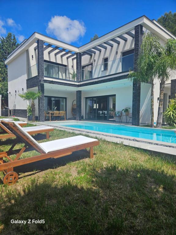 eine Villa mit Swimmingpool und ein Haus in der Unterkunft Spacieuse Villa avec piscine in Grabels