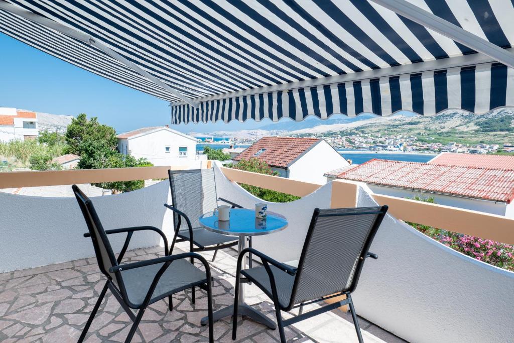 a patio with chairs and a table on a balcony at Starman Apartments in Pag