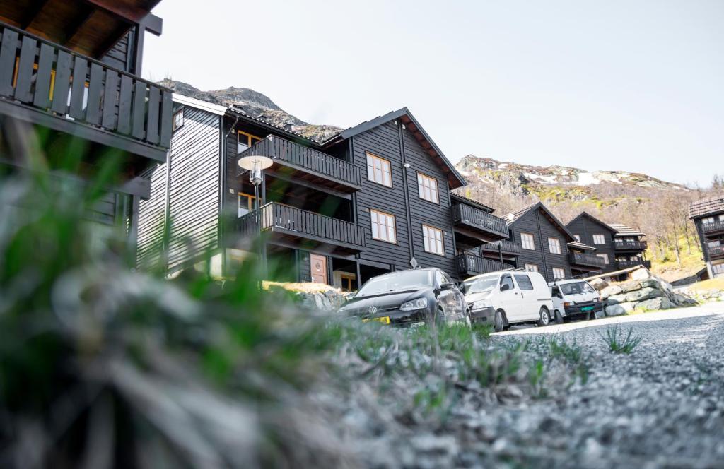 uma fila de casas com carros estacionados à frente deles em Skarsnuten Apartments em Hemsedal