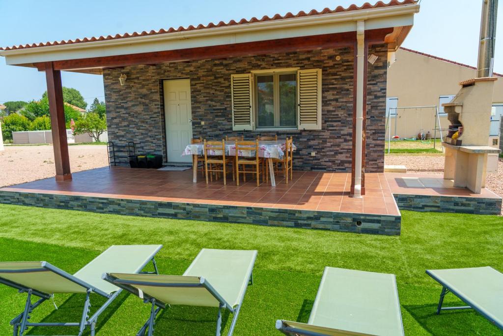 un patio con mesas y sillas en Locations l'Inzecca, en Ghisonaccia