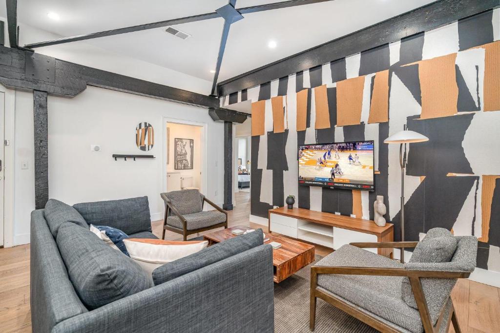 a living room with two couches and a tv at The Saddlery - Mic Drop - Walk to Broadway in Nashville