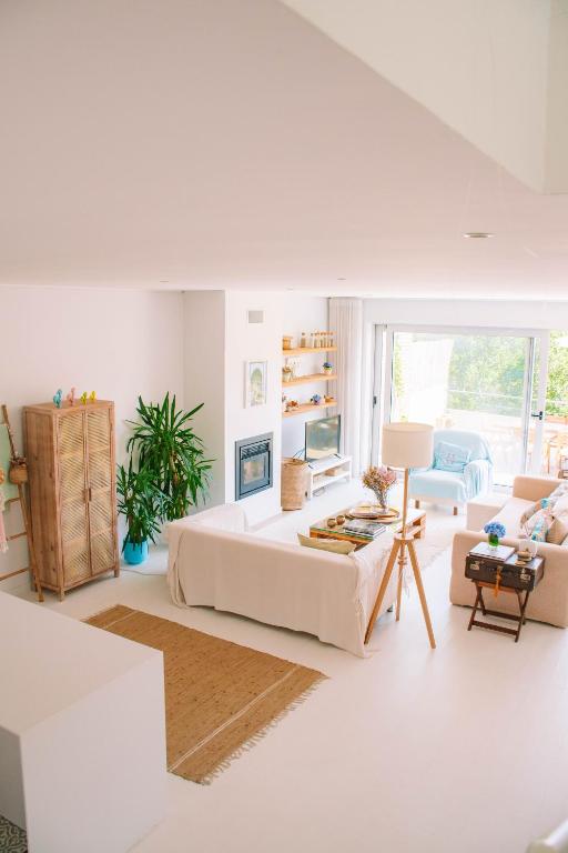 a white living room with a large couch and a table at Just Like Home - Guarda Rios in Linhares