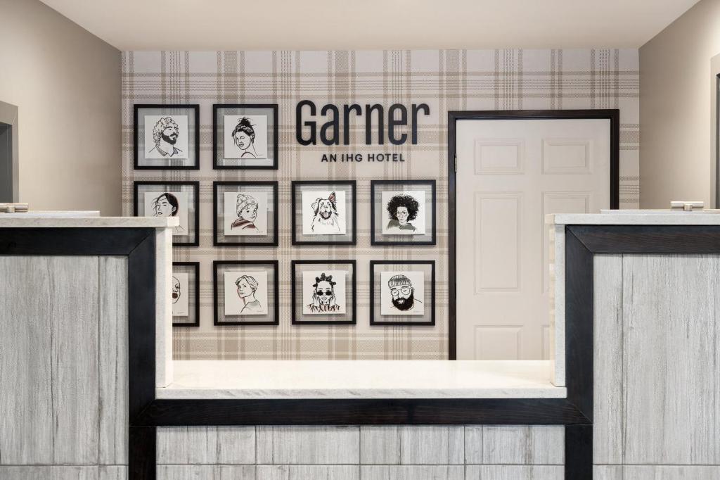 a gallery of framed pictures on a wall in a room at Garner Hotel Decatur - Forsyth by IHG in Decatur