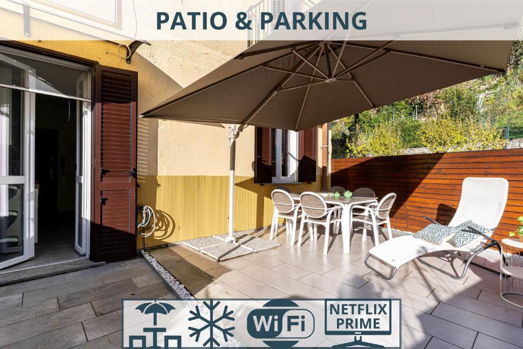 a patio with a table and chairs and an umbrella at Patio & Parking - Self check-in & Remote access in Cernobbio