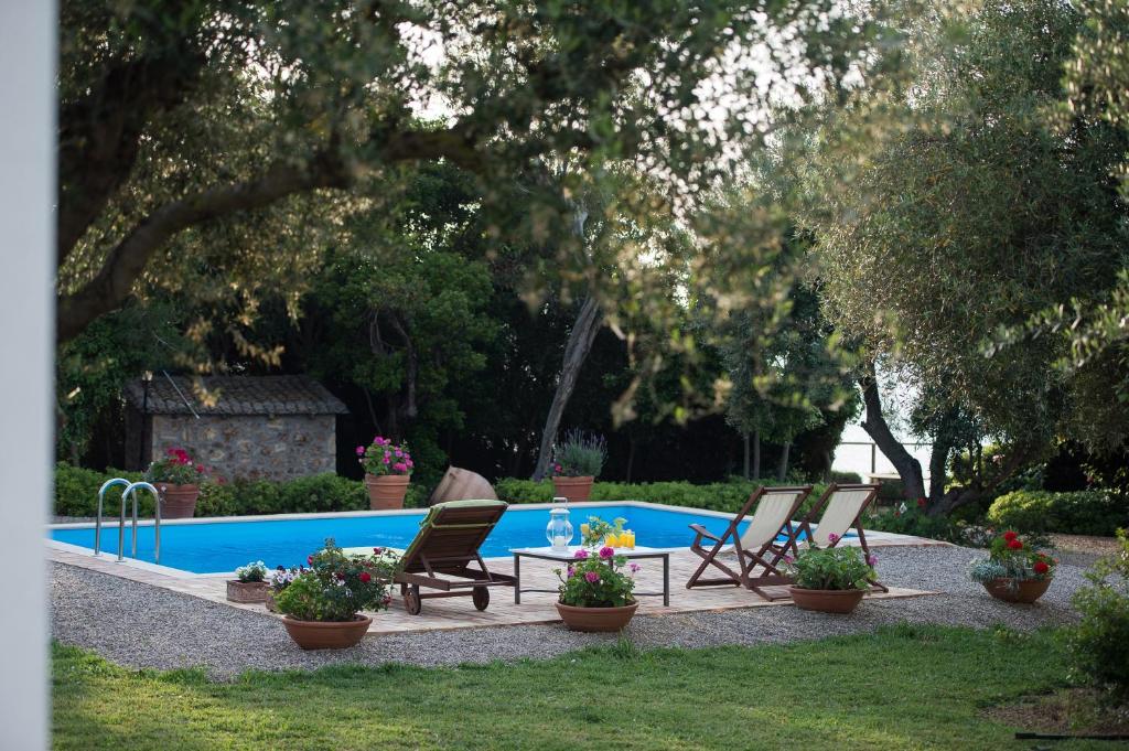 basen z 2 leżakami i kwiatami w obiekcie Villa Feia w mieście Katakolo