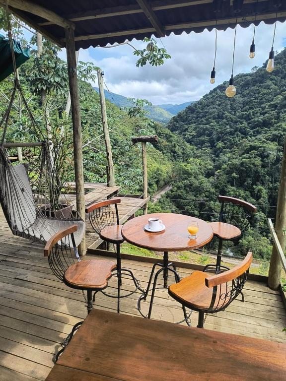 a table and chairs on a deck with a view at Eco Pousada São Francisco PETAR in Iporanga