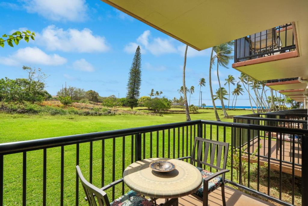 a patio with a table and chairs on a balcony at Prince Kuhio 115 in Kipu